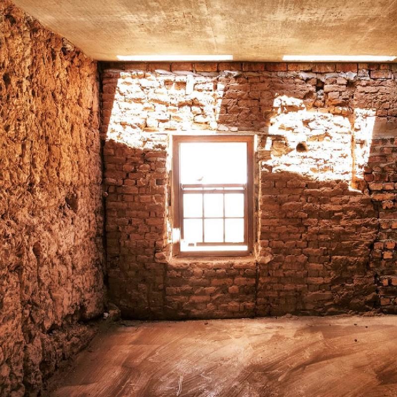 Buffelsdrift existing structure with plaster removed to reveal poured earth and clay brick